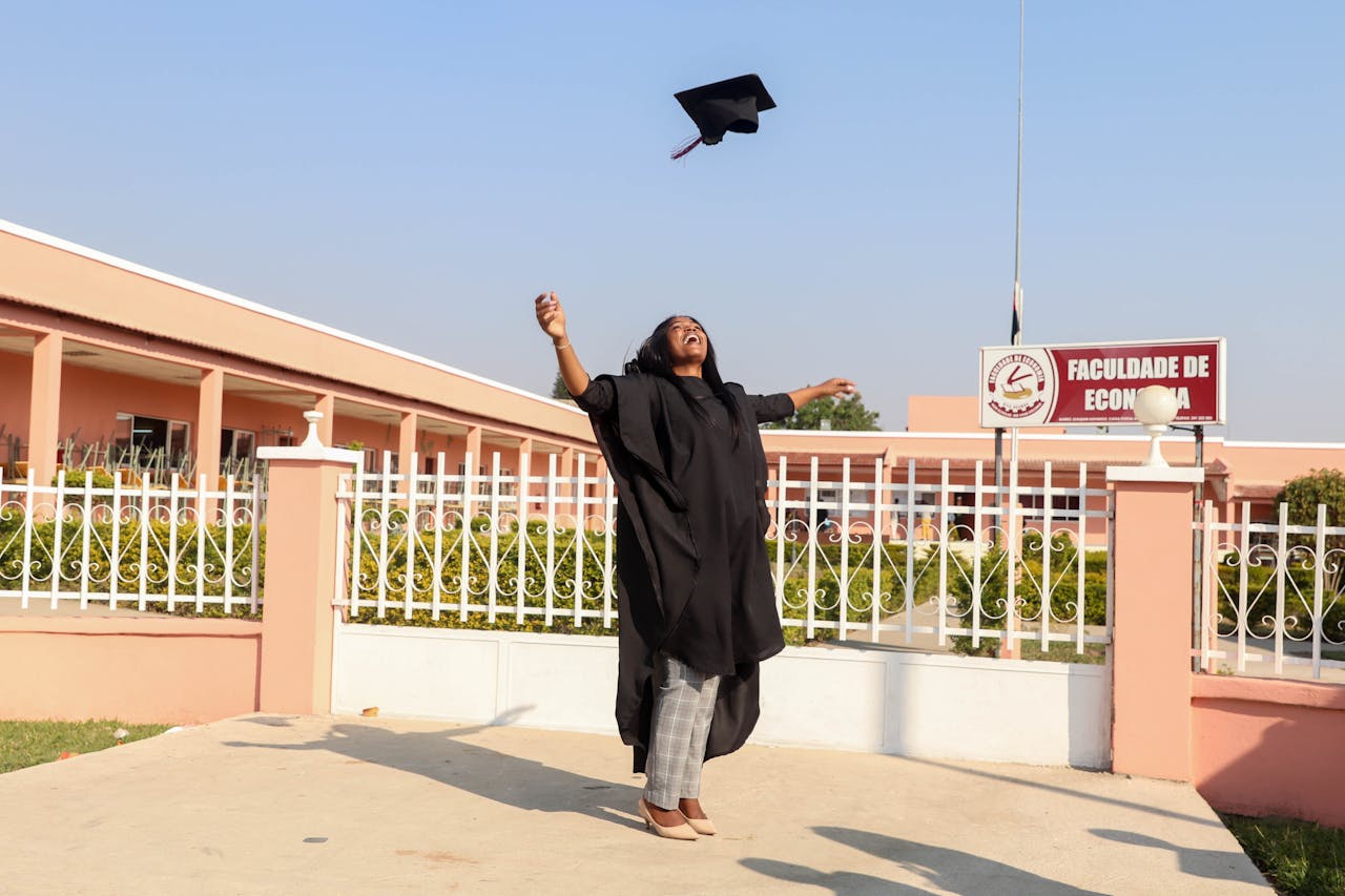 The Art of Drawing Readers In: Your attractive post title goes here A jubilant graduate celebrating outside Huambo's university with a gown and mortarboard tossed in the air.