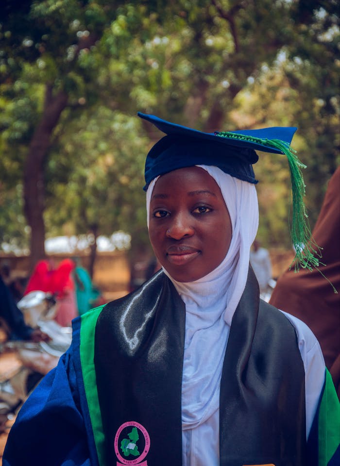 Mastering the First Impression: Your intriguing post title goes here A young woman in academic gown and hijab celebrates graduation day outdoors.