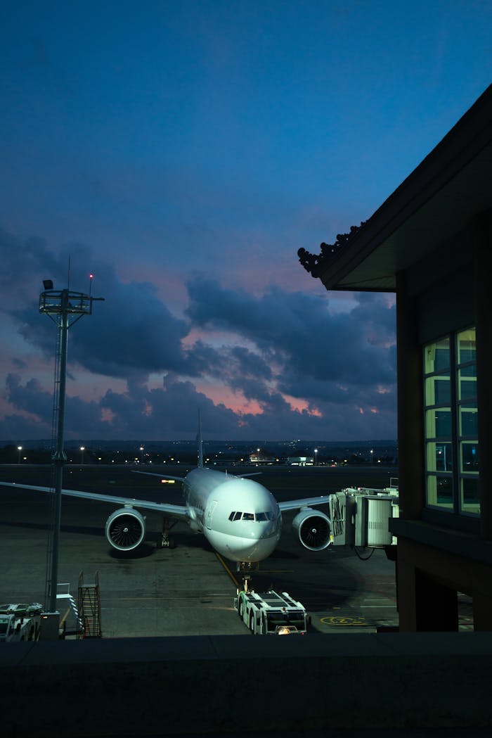 services-01 Airplane at airport with silhouette of traditional oriental building in late night twilight under spectacular sky